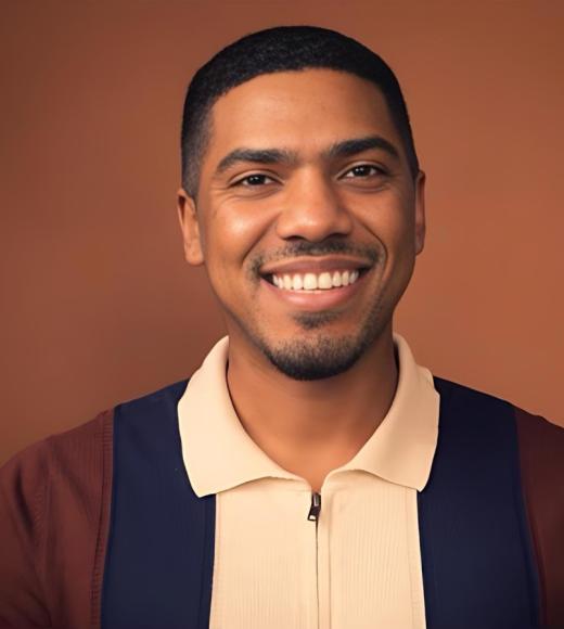 Man wearing a white, blue, and brown polo shirt standing in front of brown background