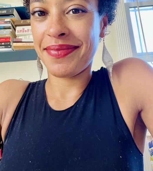 Woman with short black hair smiling wearing a black tank top