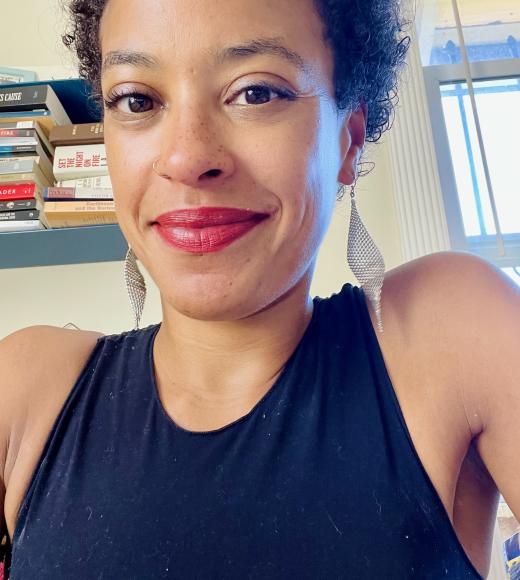 Woman with short black hair smiling wearing a black tank top
